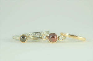 Four custom made gold rings with rough cut diamonds.